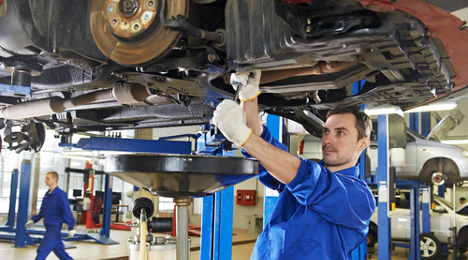 mechanic works on car